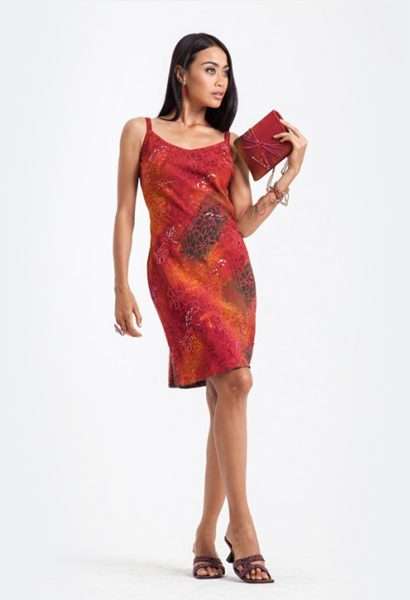 Woman in red dress holding clutch on white background