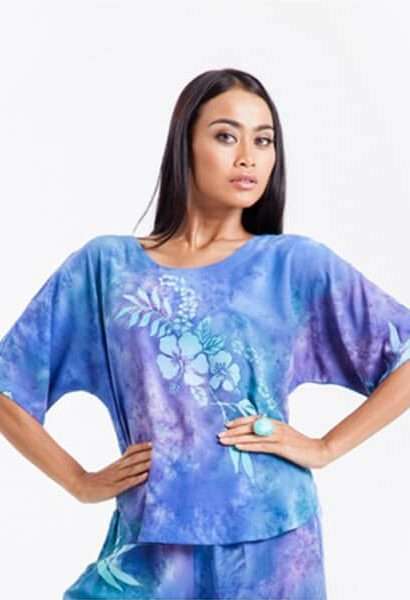Woman modeling blue tie-dye tunic with floral design