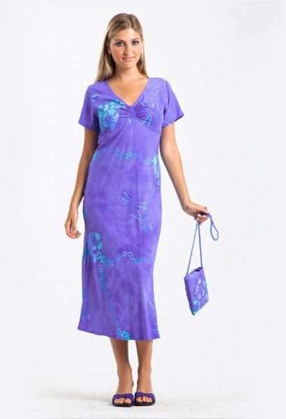 Woman in purple floral dress holding matching bag