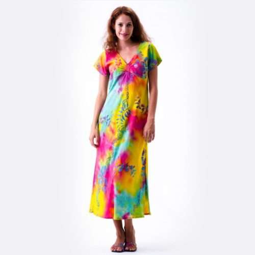 Woman in colorful tie-dye dress standing white background