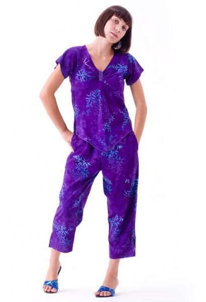 Woman in purple patterned jumpsuit posing