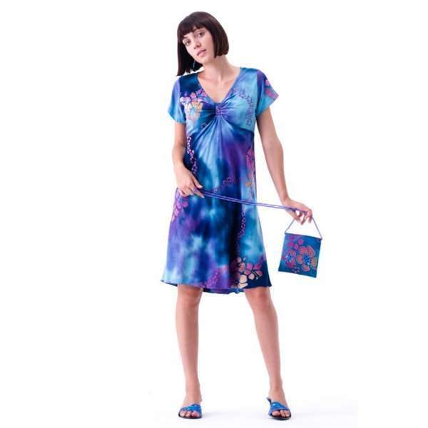 Woman in blue tie-dye dress holding matching purse