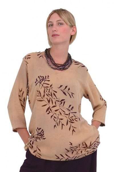 Woman modeling beige printed tunic with necklace