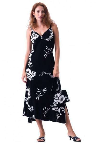 Woman in black floral dress holding matching purse