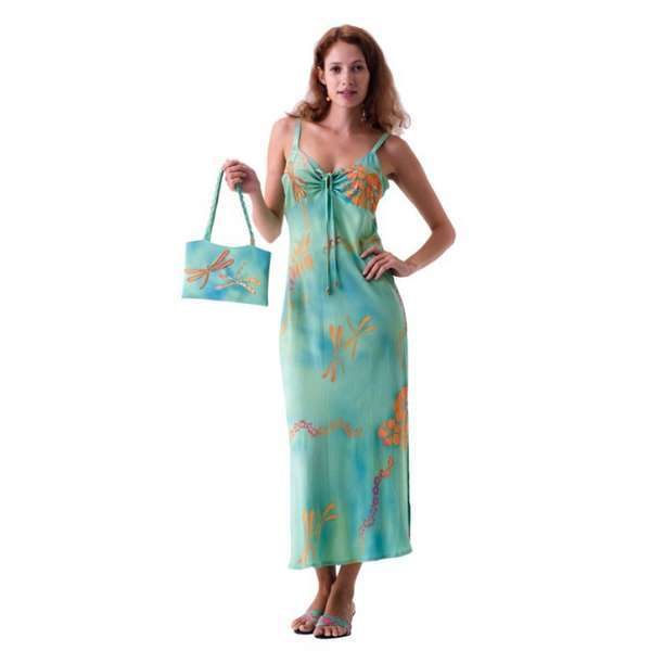 Woman in green floral dress holding matching bag