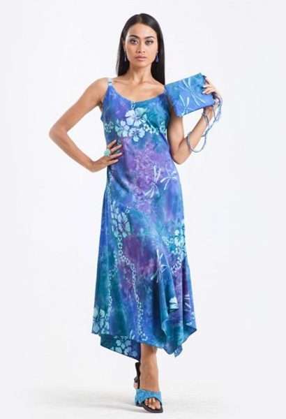 Woman modeling blue floral asymmetrical dress with purse