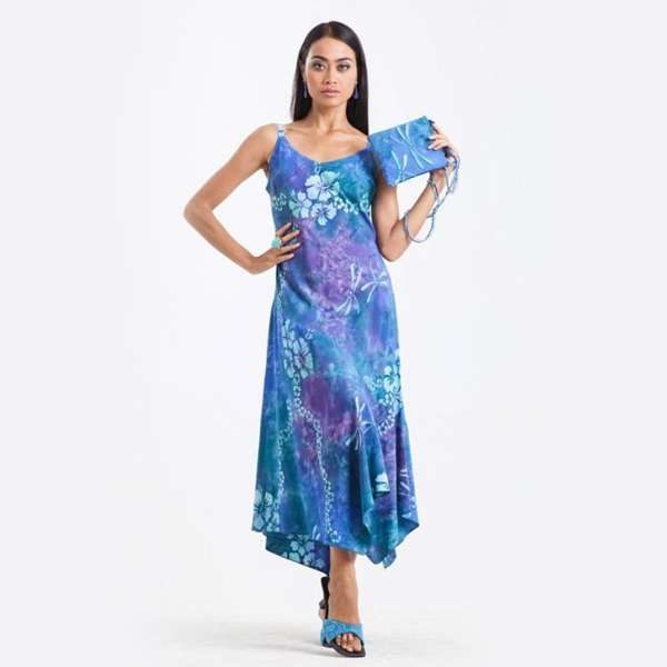 Woman modeling blue floral asymmetrical dress with purse