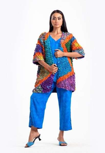 Model wearing vibrant blue outfit with colorful cardigan