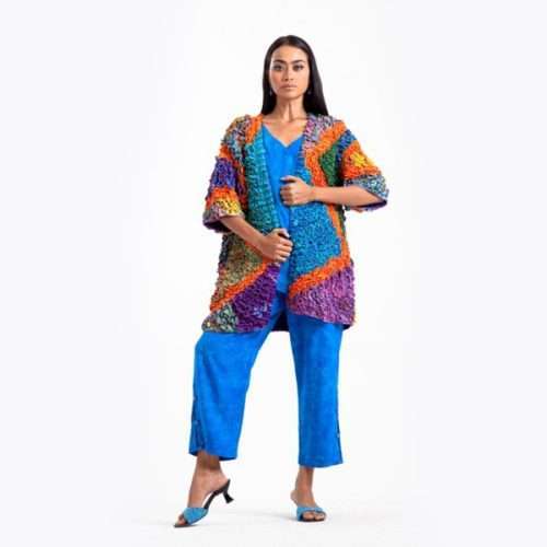 Model wearing vibrant blue outfit with colorful cardigan