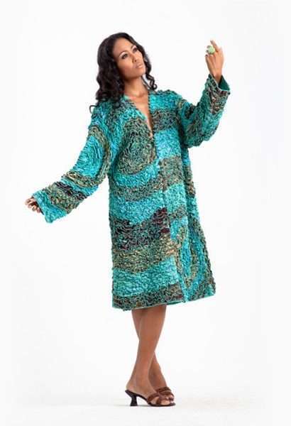 Woman in teal printed dress holding a green apple