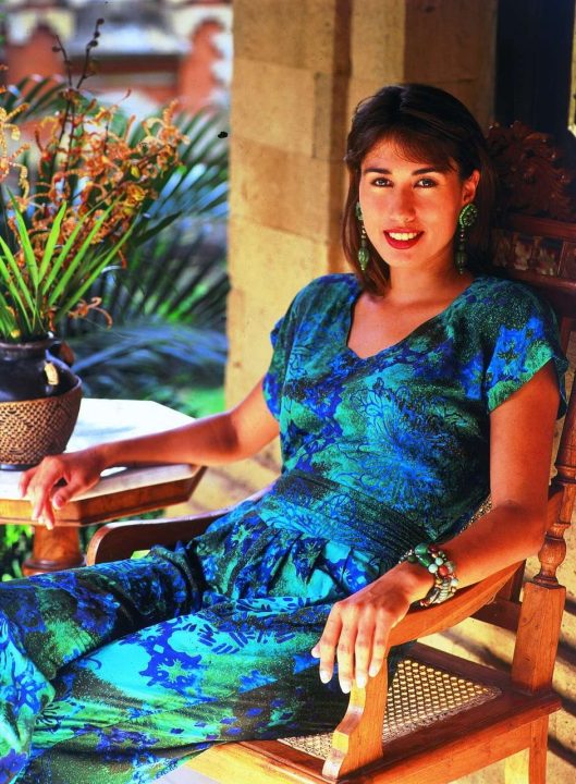 Woman in blue dress sitting on wooden chair